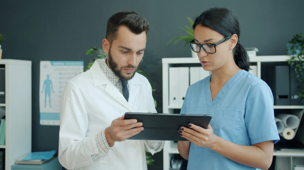 Doctor and care team member looking and working on an iPad